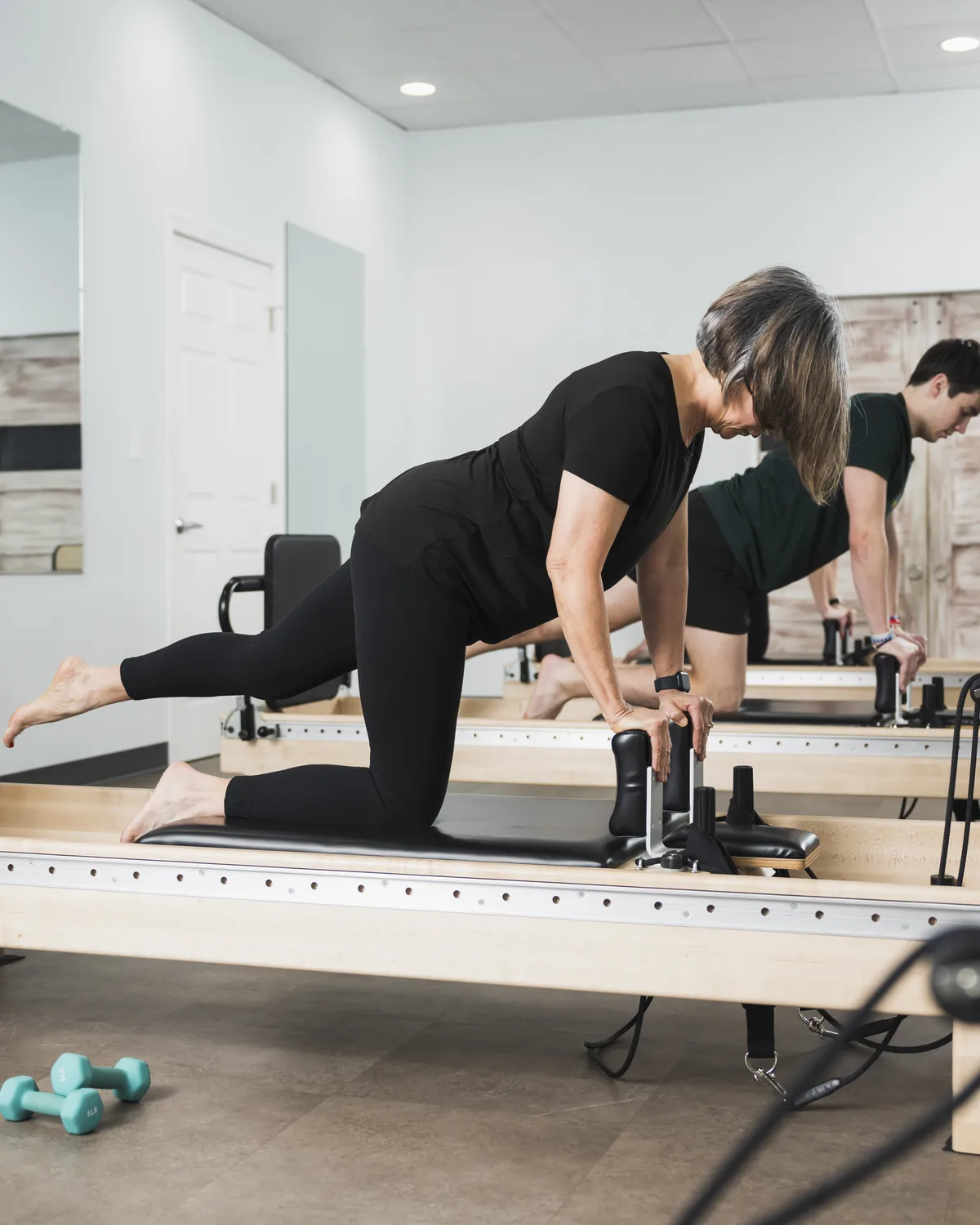 Kelly Mason, owner and Pilates instructor, working with a client at Foundations Pilates and Wellness Studio