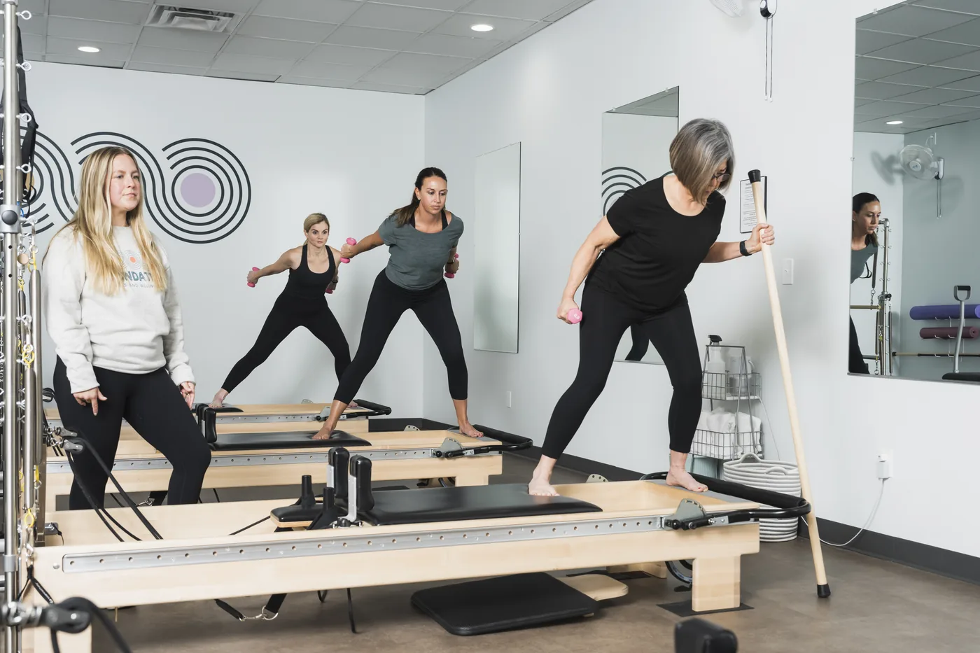 Small group of clients moving together during a mat class in the Foundations studio