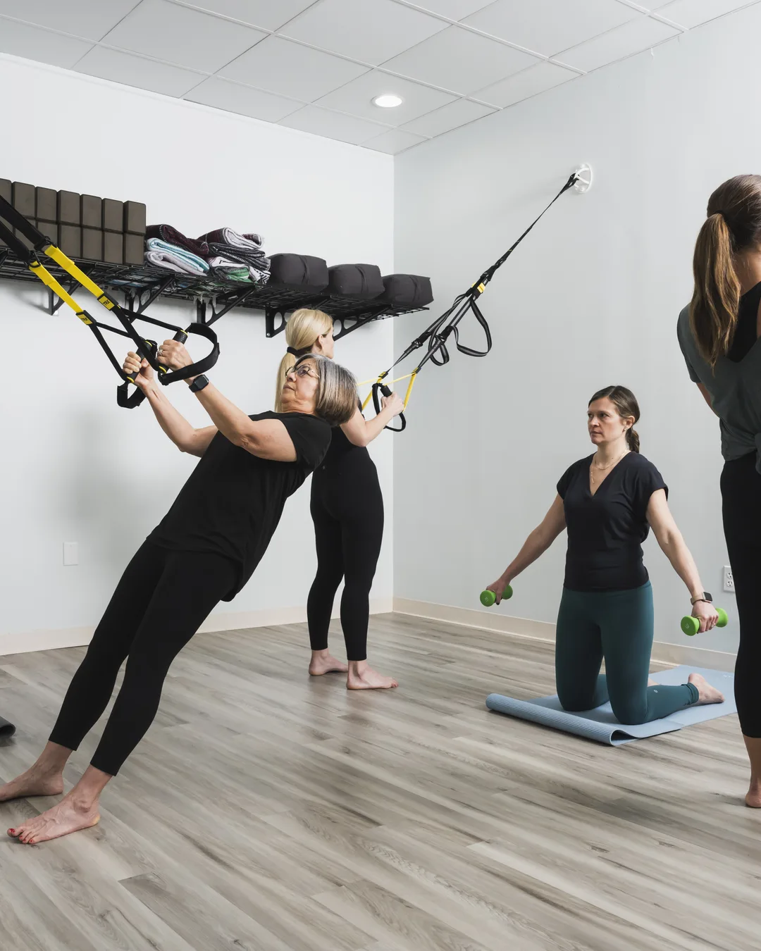 Instructor leading a Mat Pilates class on the studio floor at Foundations Pilates and Wellness Studio