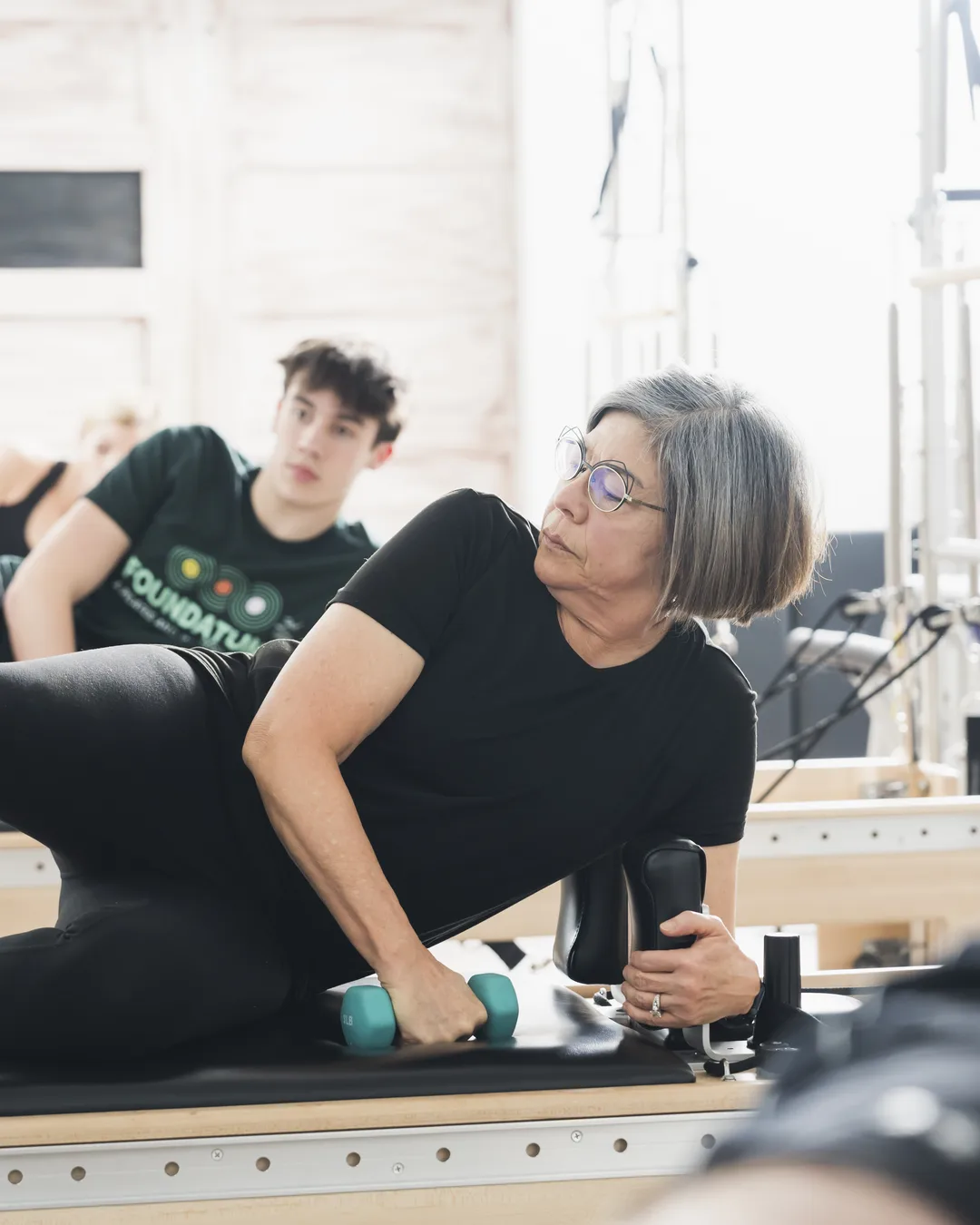 Instructor working one-on-one with a client during a private Pilates session at Foundations